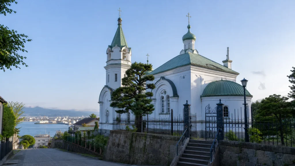 函館港を望む元町の坂に建つ白壁と緑屋根の教会外観を表した編集イメージ