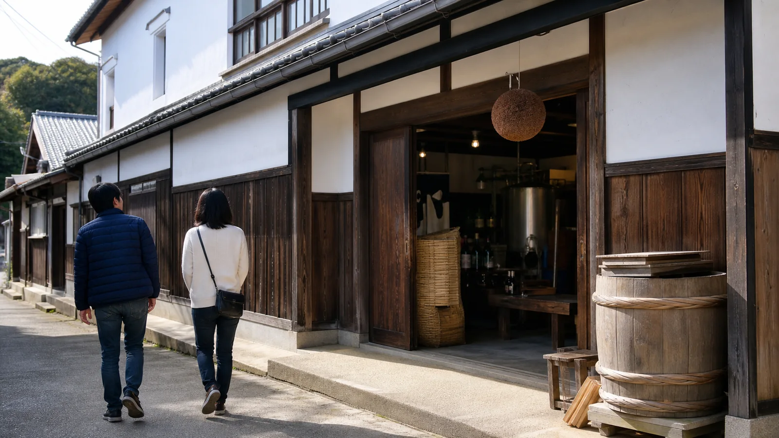 淡路島の酒蔵を思わせる白壁と木造の建物へ向かう旅行者